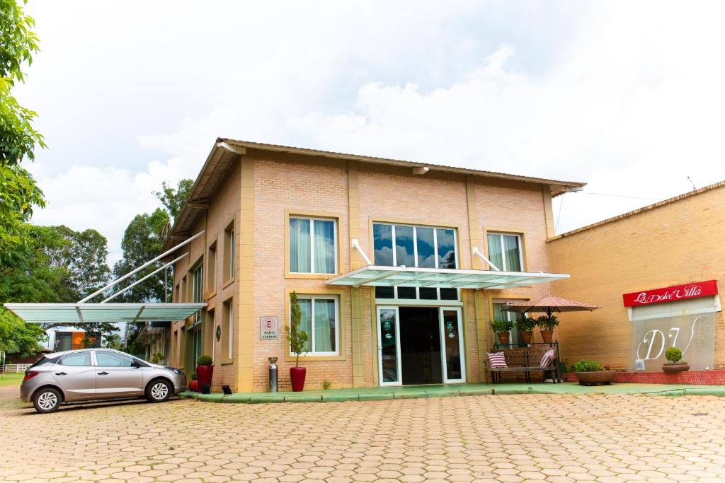 un bâtiment avec une voiture garée devant lui dans l'établissement La Dolce Villa, à Avaré