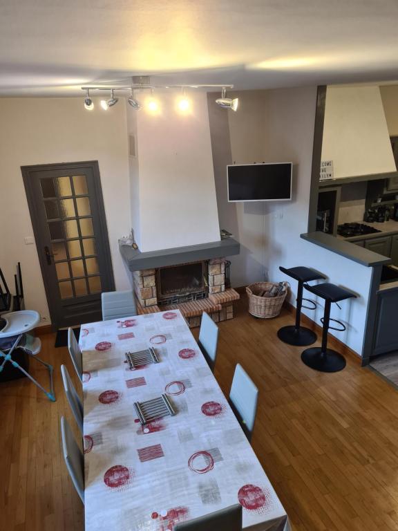 a living room with a table and a kitchen at Villa Bella à 300 m du Parc Fenestre in La Bourboule