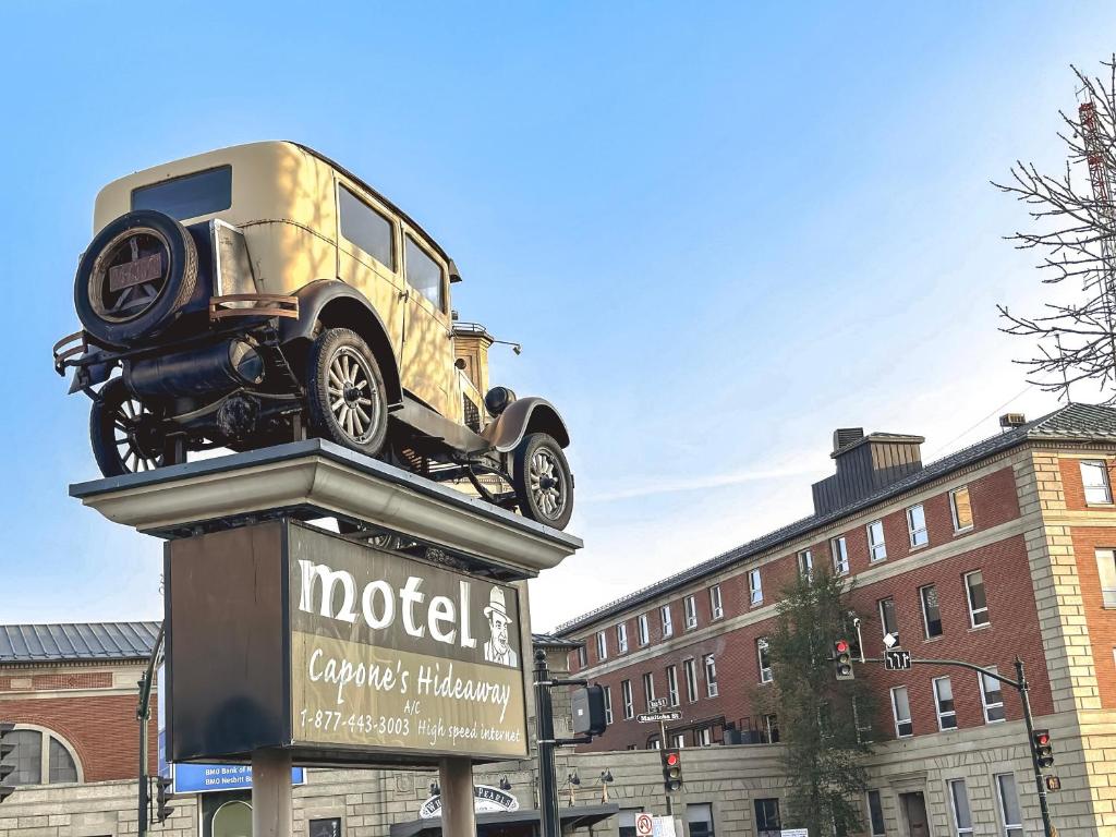 una estatua de un coche encima de una señal en Capone's Hideaway Motel, en Moose Jaw