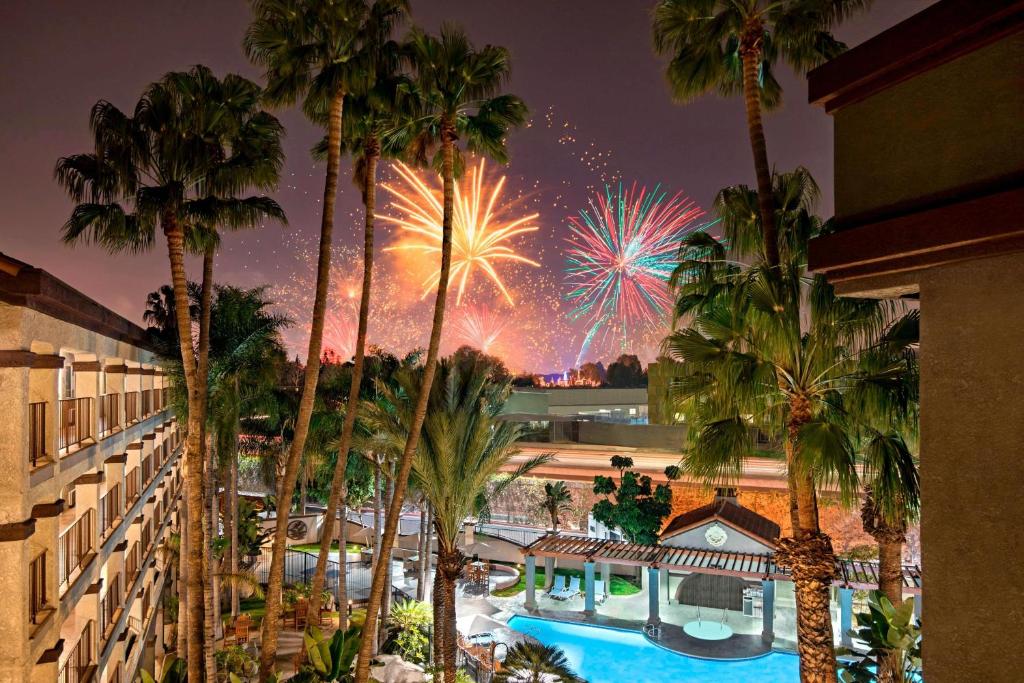 a view of a resort with palm trees and fireworks at Four Points by Sheraton Anaheim in Anaheim