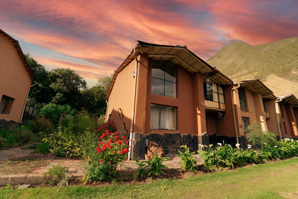 Casa cabaña privada en el Valle Sagrado Urubamba في أوروبامبا: منزل فيه ورد