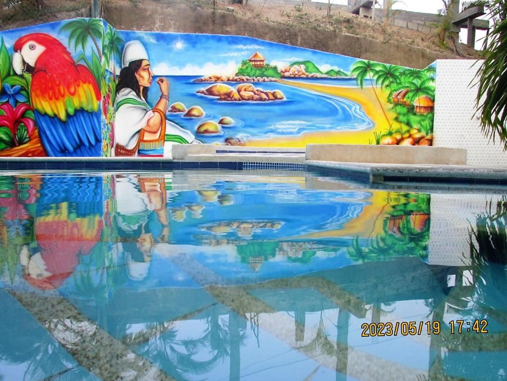 un mural pintado al lado de una piscina en Hostal Recuerdos del Tayrona, en El Zaino