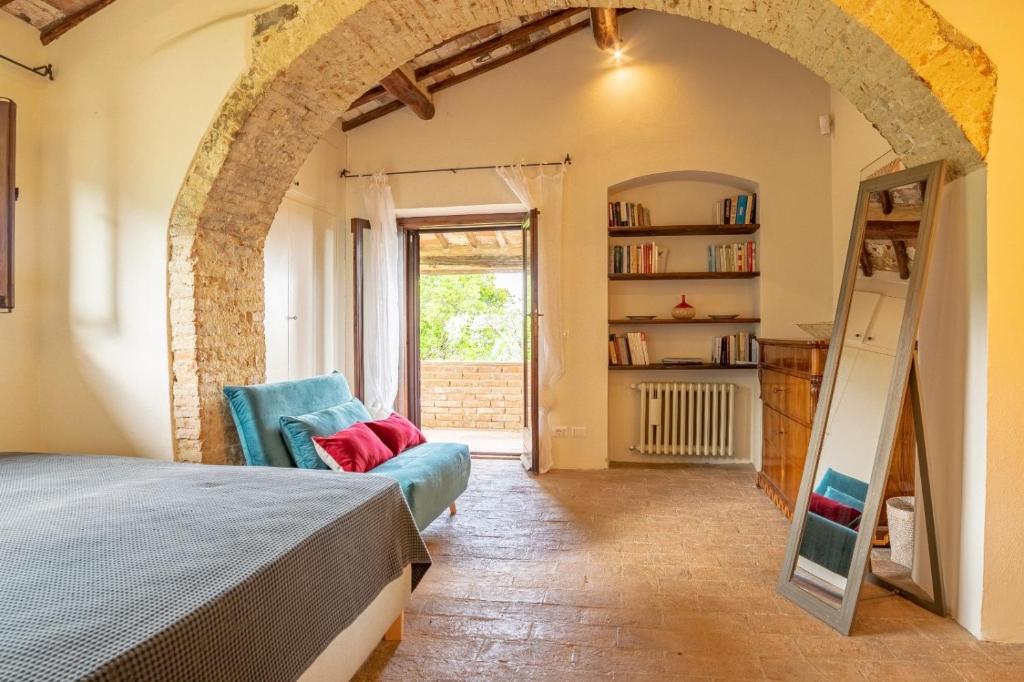 sypialnia z łóżkiem i półką na książki w obiekcie Podere Bargnano Cetona, Sleeps 12, Pool, WiFi, Air conditioning w mieście Cetona