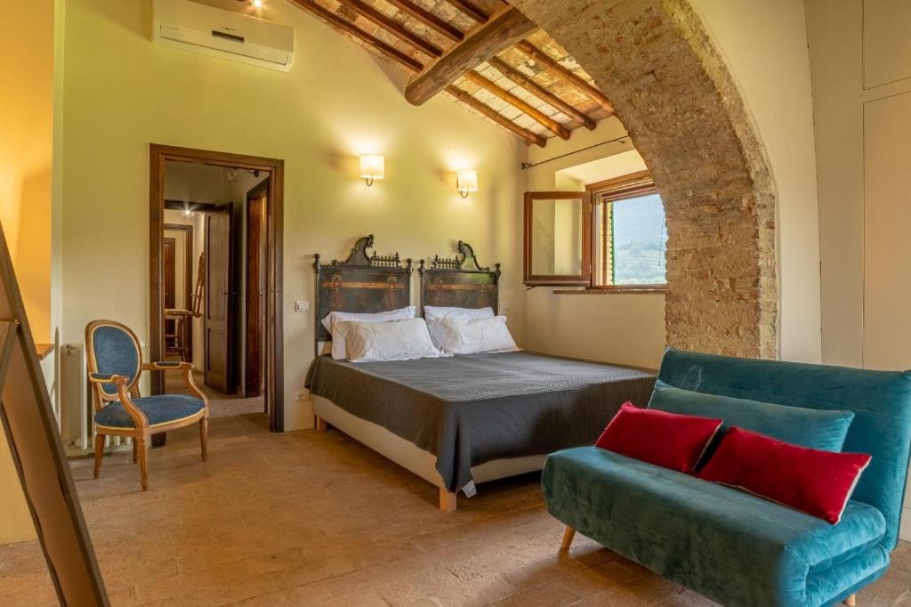 1 dormitorio con 1 cama, 1 sofá y 1 silla en Podere Bargnano Cetona, Sleeps 14, Pool, WiFi, Air conditioning, en Cetona