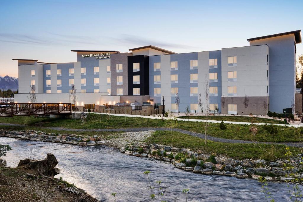un hotel con un río frente a un edificio en TownePlace Suites by Marriott Logan, en Logan