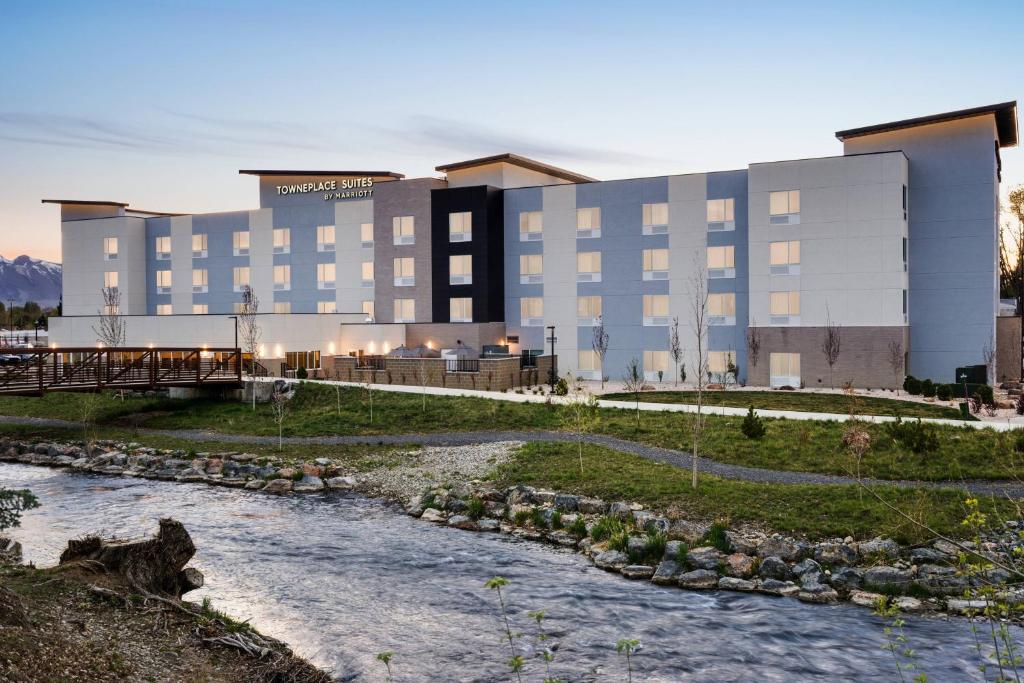 a hotel with a river in front of a building at TownePlace Suites by Marriott Logan in Logan