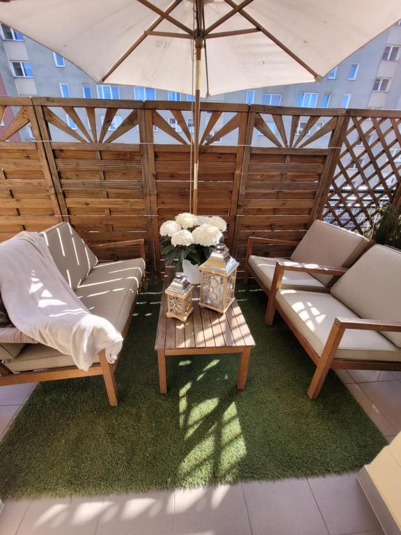 a patio with two couches and a table with flowers at Apartament Czerwone Maki in Warsaw