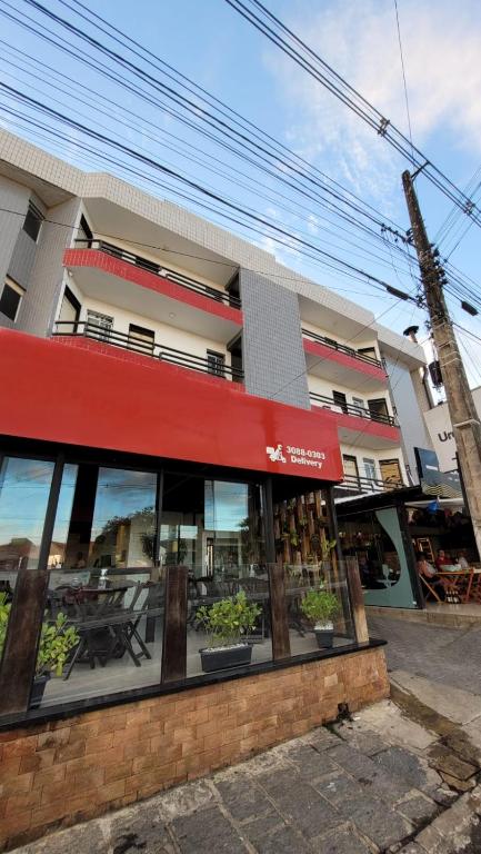 a restaurant with a red awning in front of a building at Apartamento completo para São João in Campina Grande