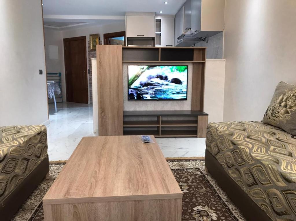 uma sala de estar com um sofá e uma televisão em Studio au résidence MALAK em Agadir