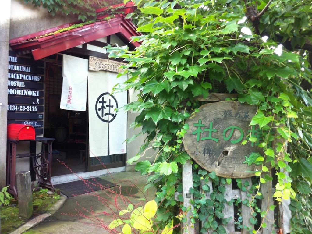 um edifício com uma hera verde a crescer nele em The Otaornai Backpacker's Hostel Morinoki em Otaru