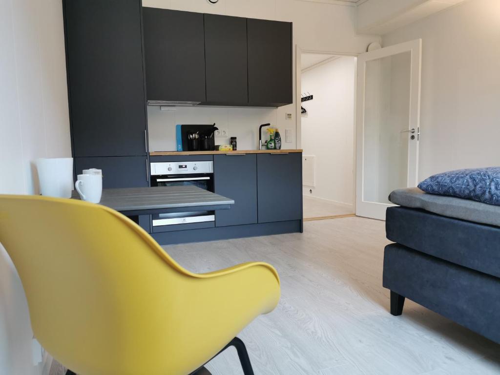 eine Küche mit einem gelben Stuhl in einem Zimmer in der Unterkunft Lofoten Studio Apartment, Vestermyrveien 11 Svolvær in Svolvær