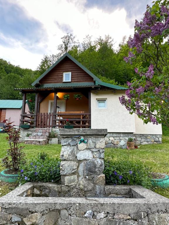 une maison avec un mur en pierre devant elle dans l'établissement Holiday House Tara, à Kolašin