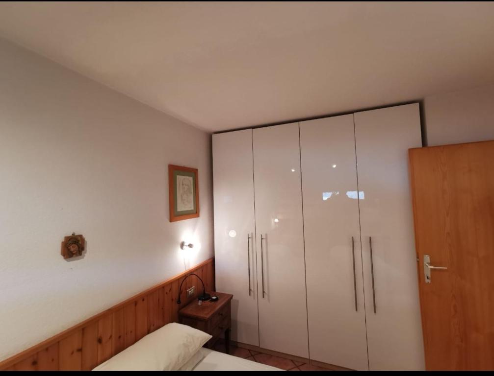 a bedroom with a bed and a large white cabinet at Val di Sole Holidays in Folgarida