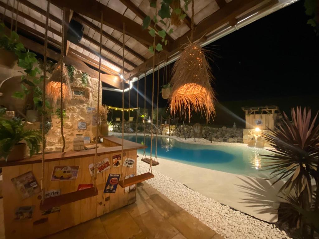 a swimming pool with a resort at night at Le Relais de la Chouette in Berson