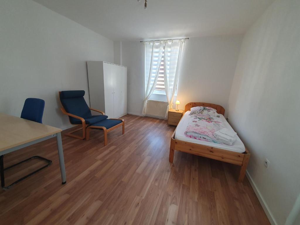Habitación pequeña con cama, escritorio y silla. en Privatzimmer an der Uniklinik Mainz, en Mainz