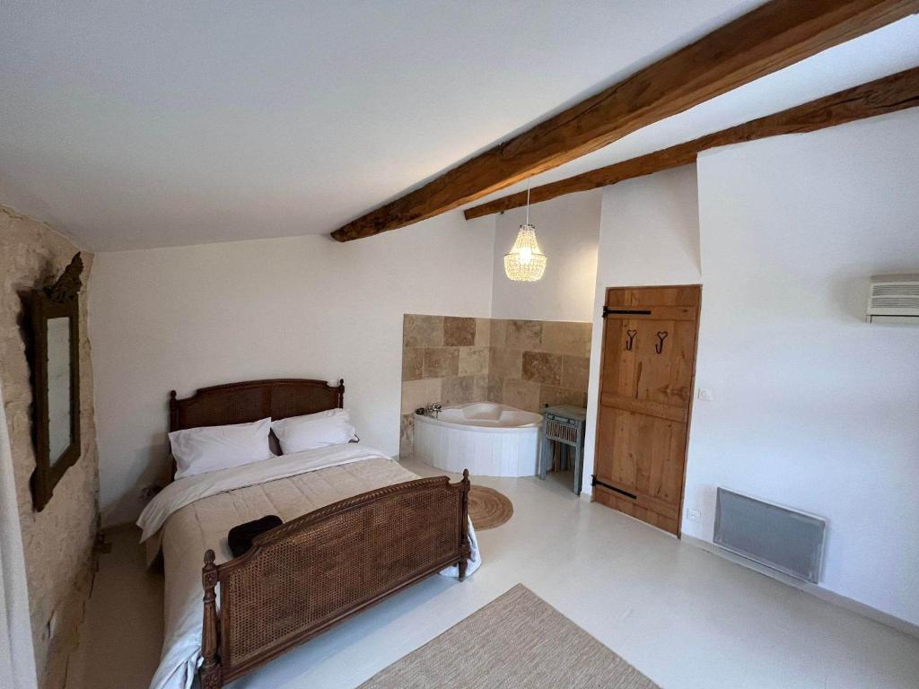 a bedroom with a bed and a tub in it at No 10 Vic Fezensac in Vic-Fezensac