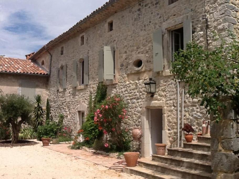 - un bâtiment en pierre avec des escaliers et des fleurs devant dans l'établissement La Manhanéra, à Bouquet