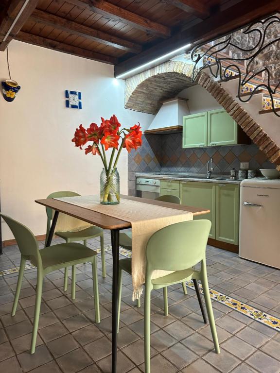 uma cozinha com uma mesa e cadeiras com um vaso de flores em Casa Rappini em Terracina