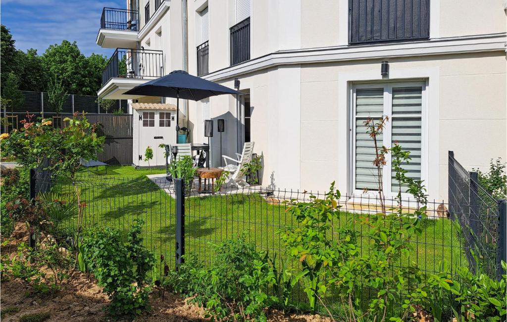 - un jardin avec un parasol en face d'une maison dans l'établissement Gorgeous Apartment In Le Blanc-mesnil With Kitchen, au Blanc-Mesnil