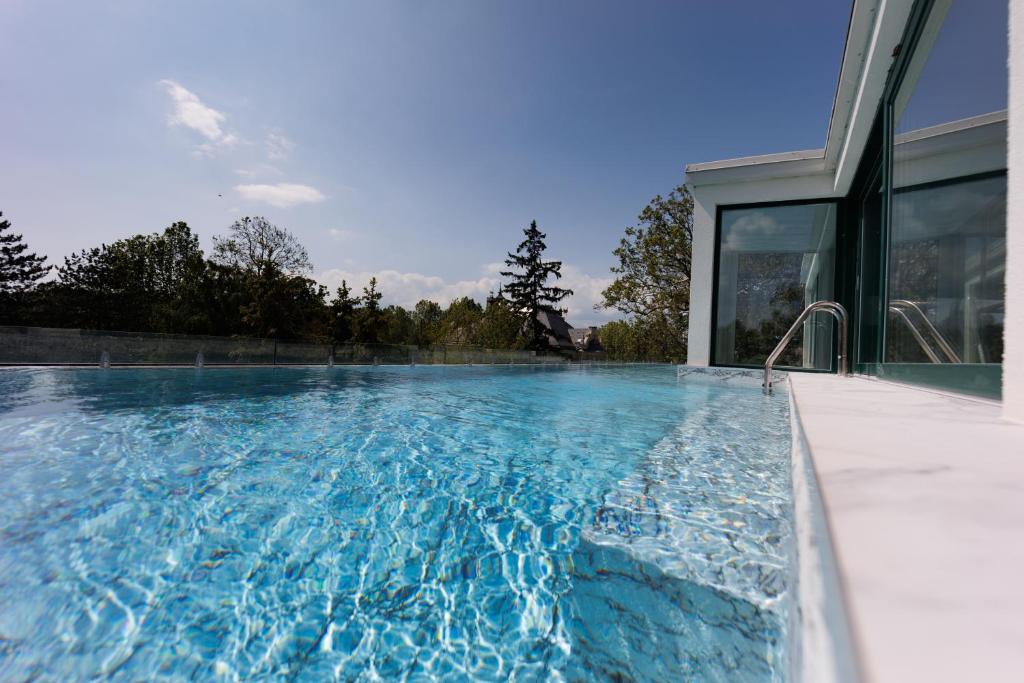 a swimming pool in the backyard of a house at Villa Bauhaus Wellness Apartman in Siófok