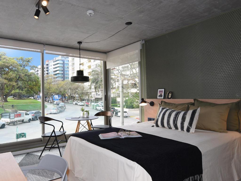 a bedroom with a large bed and a large window at Diseño con vistas al Parque y Mar Punta Carretas in Montevideo