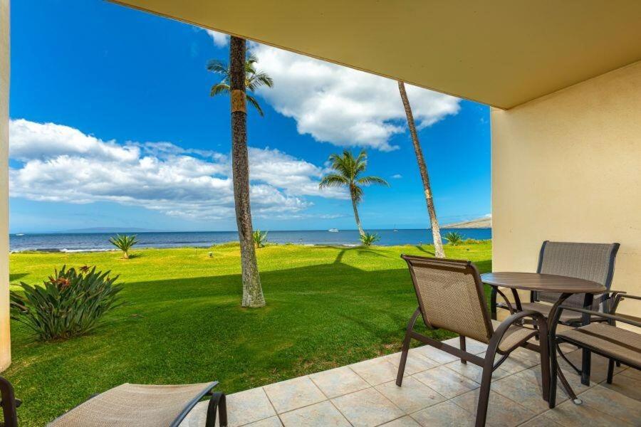 a patio with a table and chairs and the ocean at SUGAR BEACH RESORT, #121 condo in Kihei