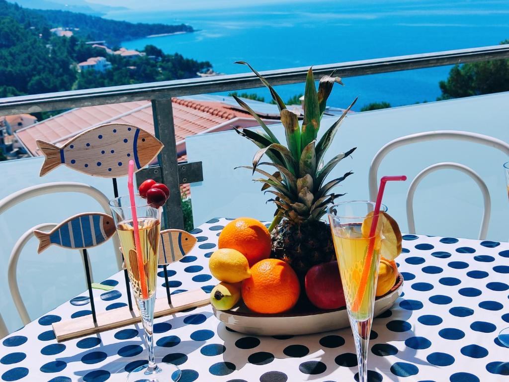 un bol de fruta en una mesa con dos vasos en APARTMANI NADA MUSTAPIC, en Brela