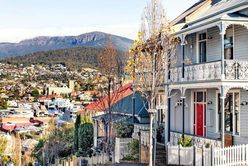 una casa con una puerta roja en una ciudad en The Glebe Cottage, en Hobart