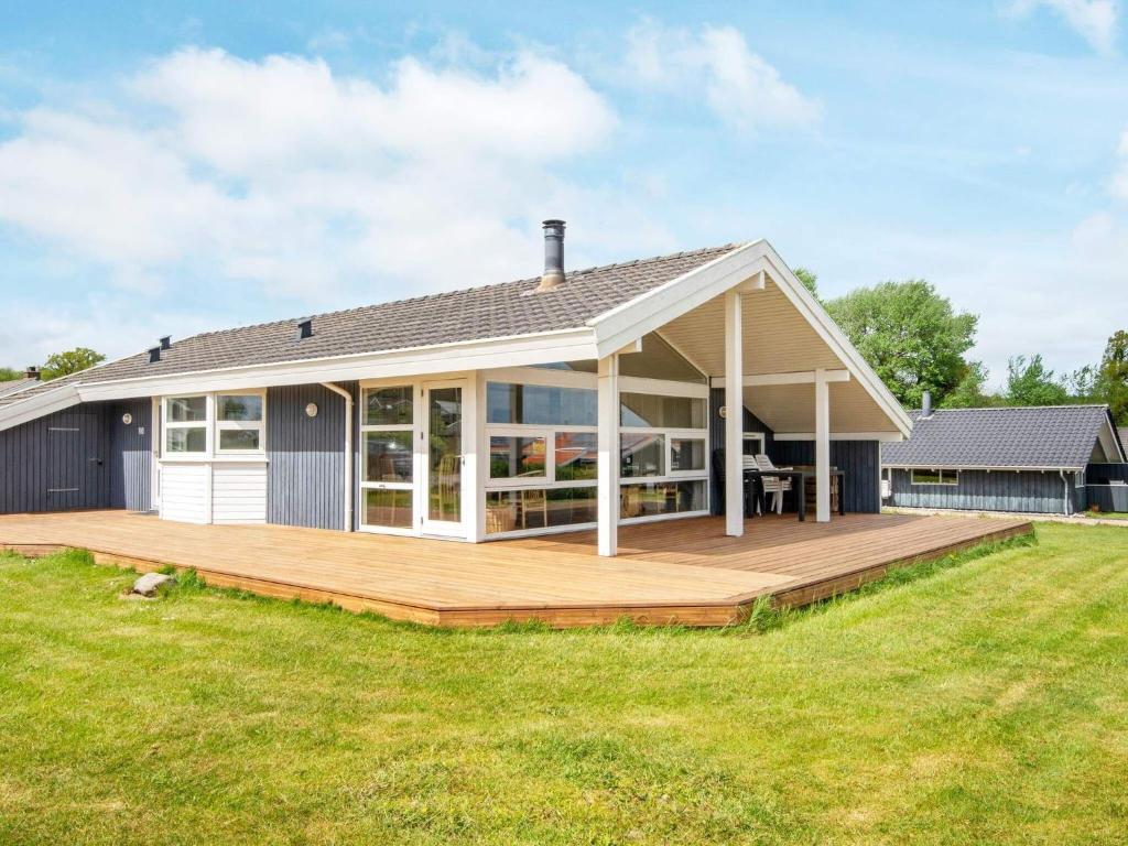 HejlsにあるThree-Bedroom Holiday home in Sjølund 4の芝生の上に広いデッキがある家