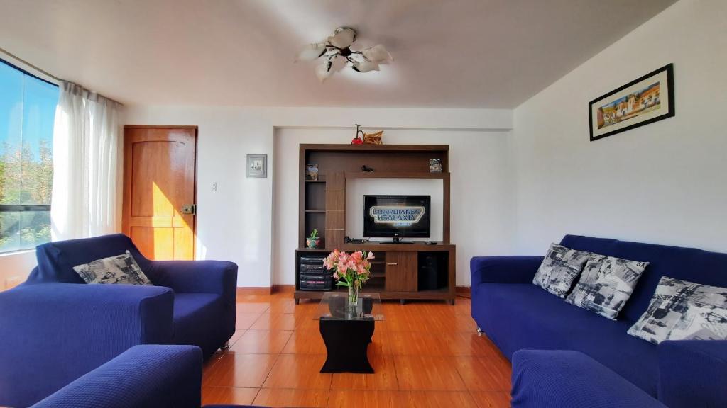 uma sala de estar com dois sofás azuis e uma televisão em DEPARTAMENTO CÉNTRICO , CÓMODO Y ECONÓMICO EN CUSCO em Cusco