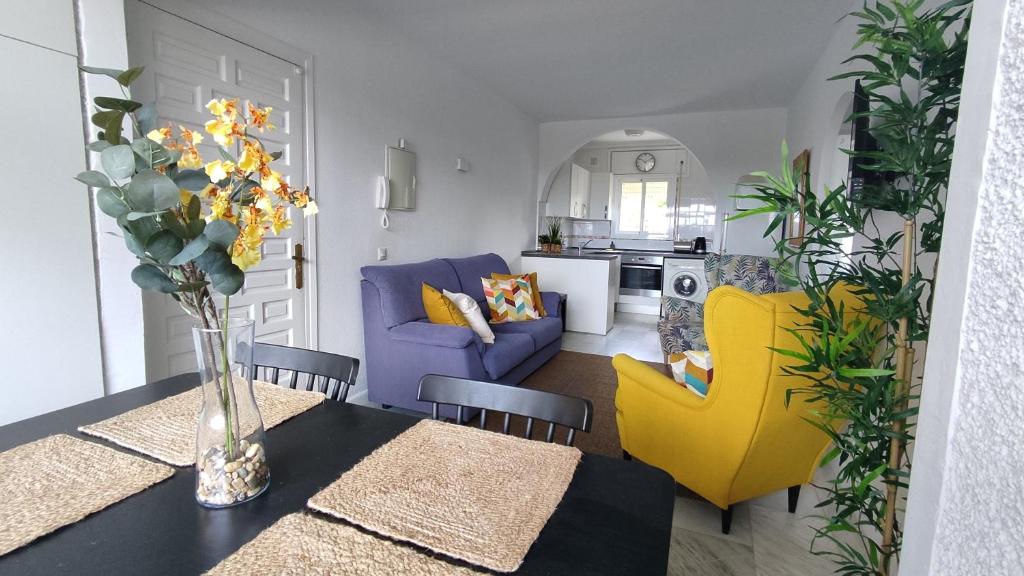 Una sala de estar con una mesa y sillas amarillas. en La Cala playa, en La Cala de Mijas