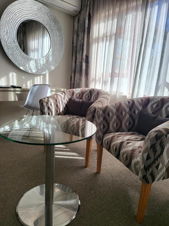 a living room with a couch and a glass table at ASURE Destiny on Fitzherbert Motel in Palmerston North