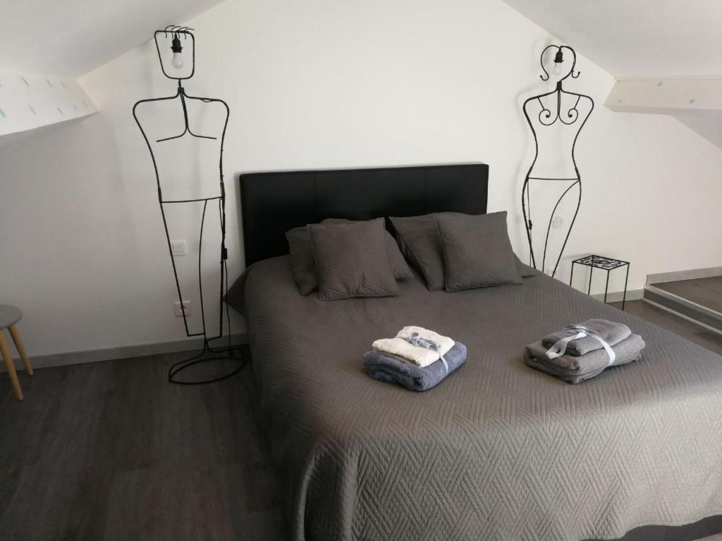 a bedroom with a bed with two mannequins on it at palalain appartement in Tarbes