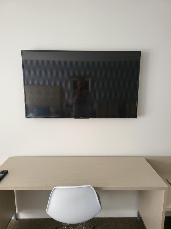 a white desk with a monitor and a chair at ASURE Destiny on Fitzherbert Motel in Palmerston North
