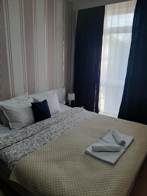 a bed with a towel on it with a window at Bulevar Star Apartment in Belgrade