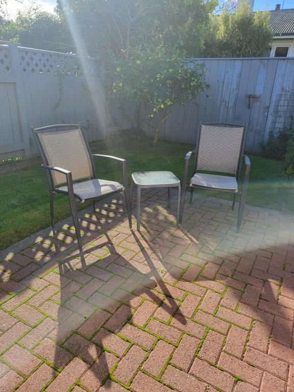 two chairs and a table on a brick patio at ASURE Destiny on Fitzherbert Motel in Palmerston North
