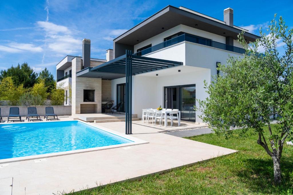 a villa with a swimming pool in front of a house at Kuća za odmor Marita in Privlaka