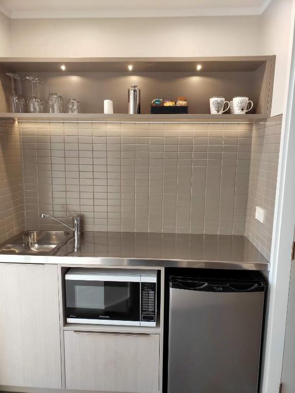 a kitchen with a microwave and a sink at ASURE Destiny on Fitzherbert Motel in Palmerston North