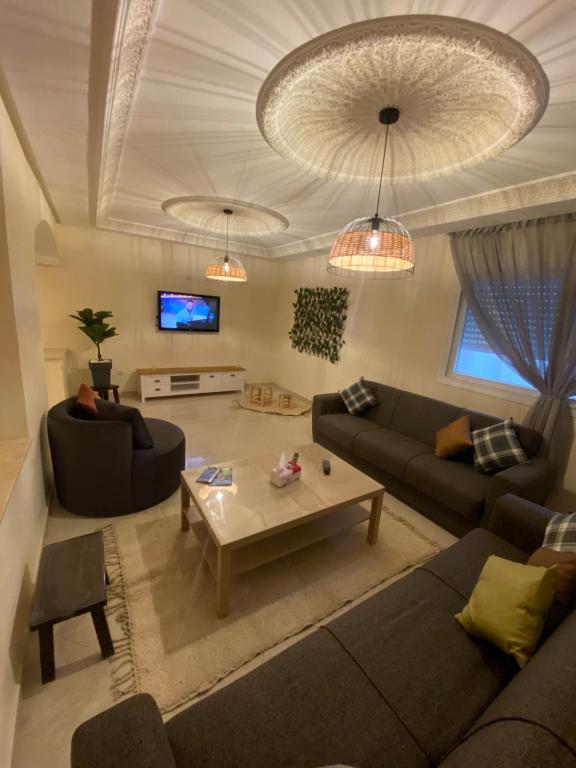 a living room with two couches and a coffee table at Appartement kenzi Beach in Tangier
