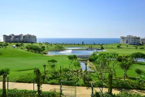 a view of a golf course with the ocean in the background at Prestigieux Appartement à Marina Assilah Golf in Asilah
