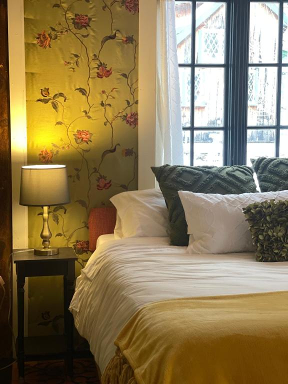 um quarto com uma cama e um papel de parede florido em The Four Pillars Farmstead 