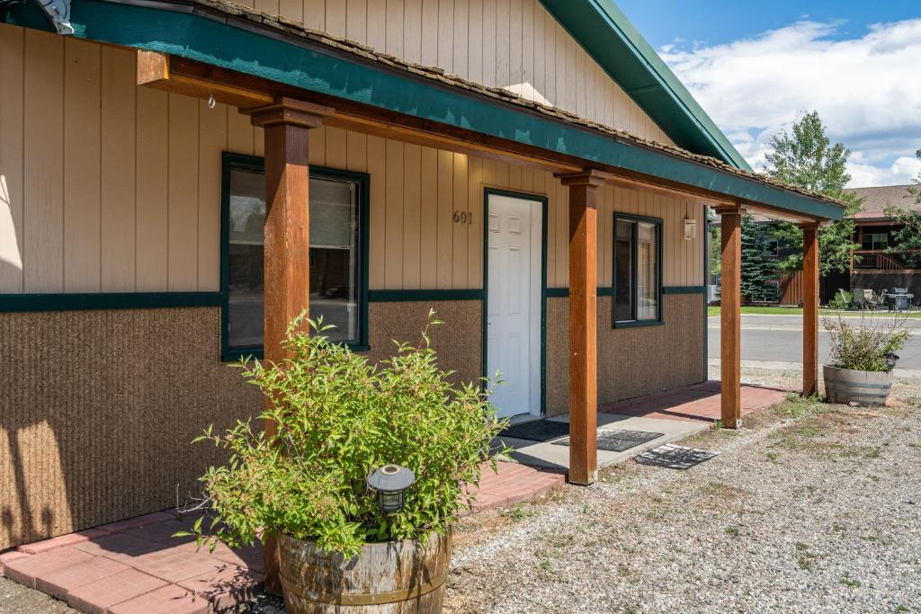 Cette petite maison dispose d'une terrasse couverte et d'une porte blanche. dans l'établissement Alpine #2, à West Yellowstone