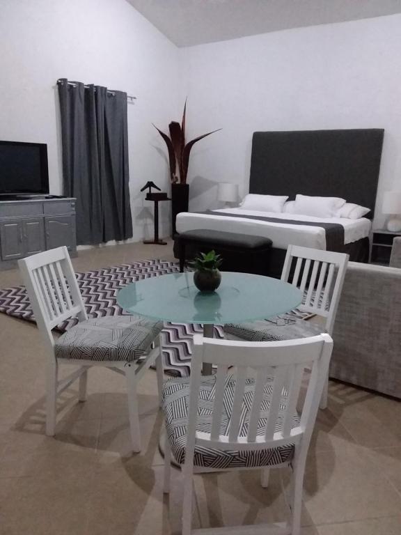 uma sala de estar com uma mesa e cadeiras e um sofá em Junior suite Privada 7 min del Aeropuerto em Cancún