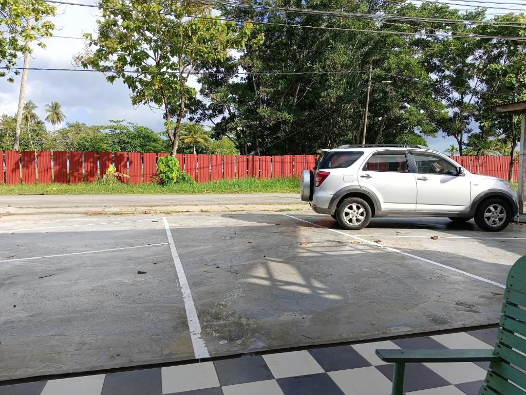 un coche blanco aparcado en un estacionamiento en DAOH'S Rooms & Scooters, en Tanjung Rhu