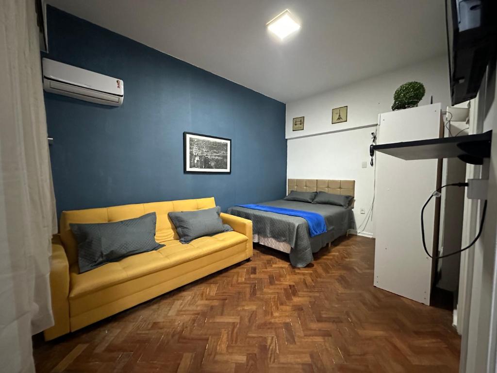 uma sala de estar com um sofá e uma cama em Residencial Praia do Flamengo - Zona Sul Rio de Janeiro no Rio de Janeiro