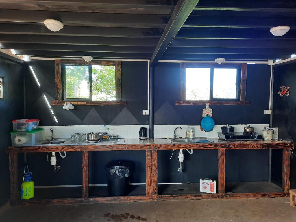 a kitchen with blue walls and a counter with two windows at Moehiva Camping Rapa Nui in Hanga Roa