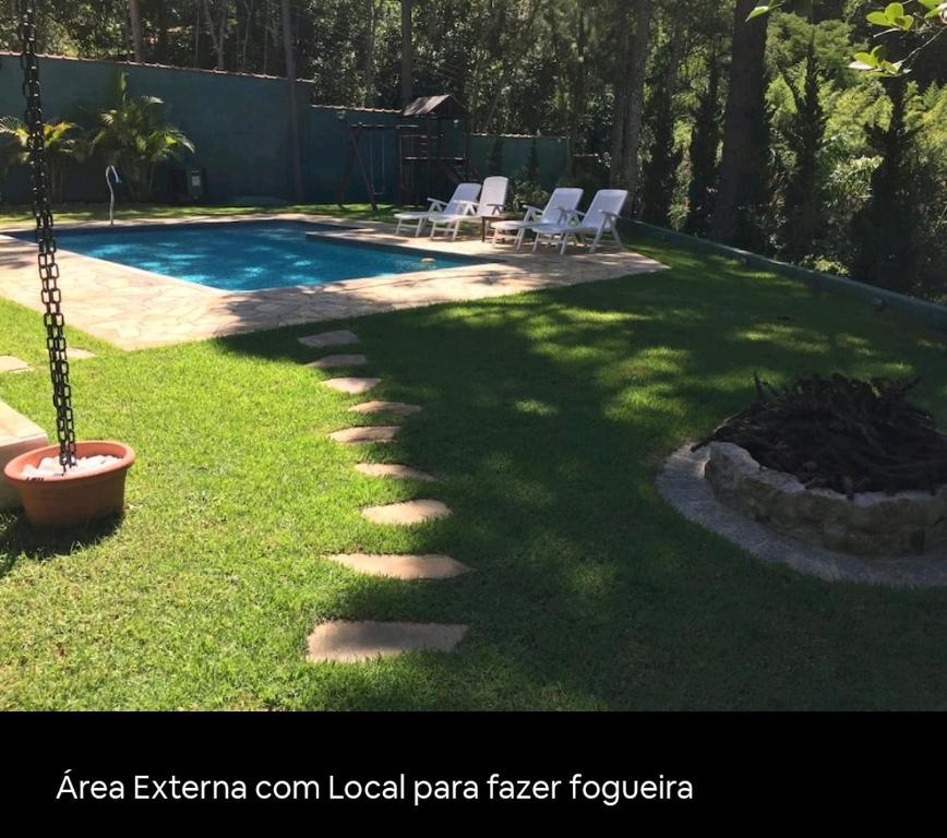 een achtertuin met een zwembad en een patio met een vuurplaats bij Chacara com Piscina Aquecida in Guarulhos