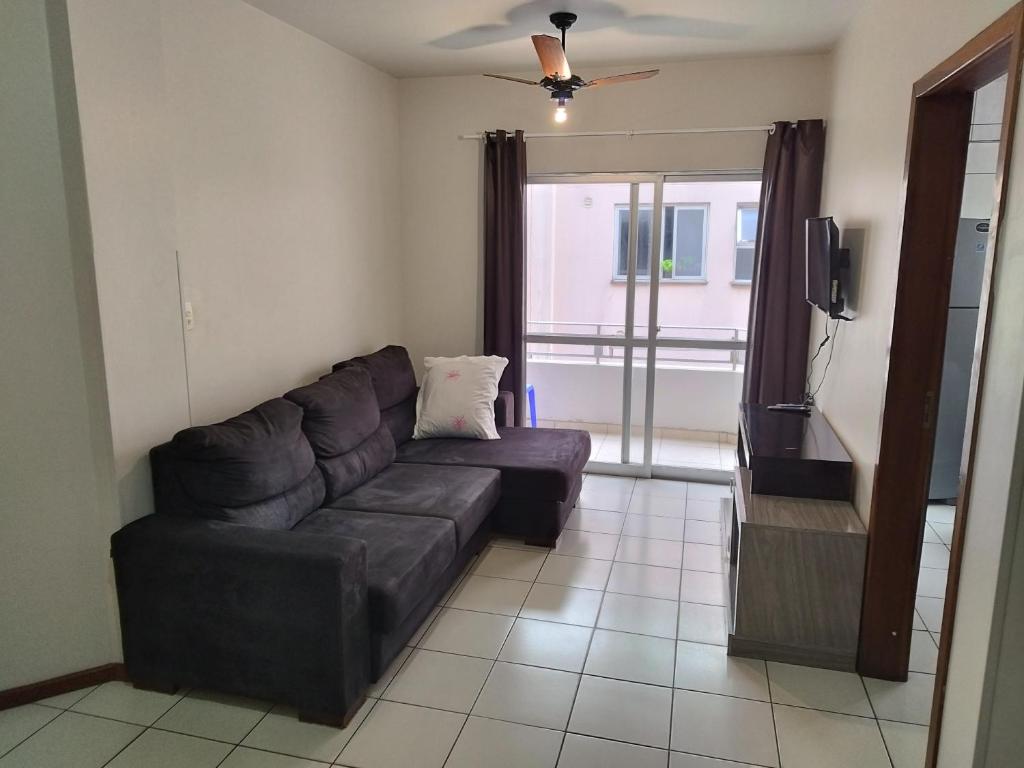 a living room with a couch and a tv at APT Praia Central Itapema 90MTS do Mar in Itapema