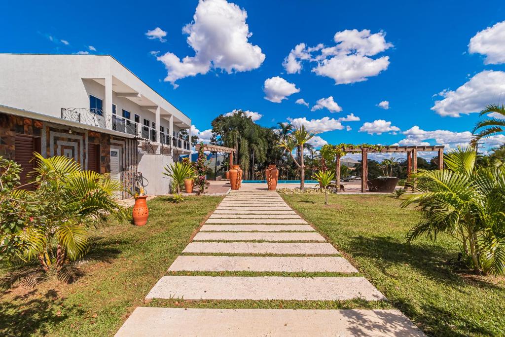 a pathway in front of a building with a blue sky at Pousada Nobre Vista in Pirenópolis