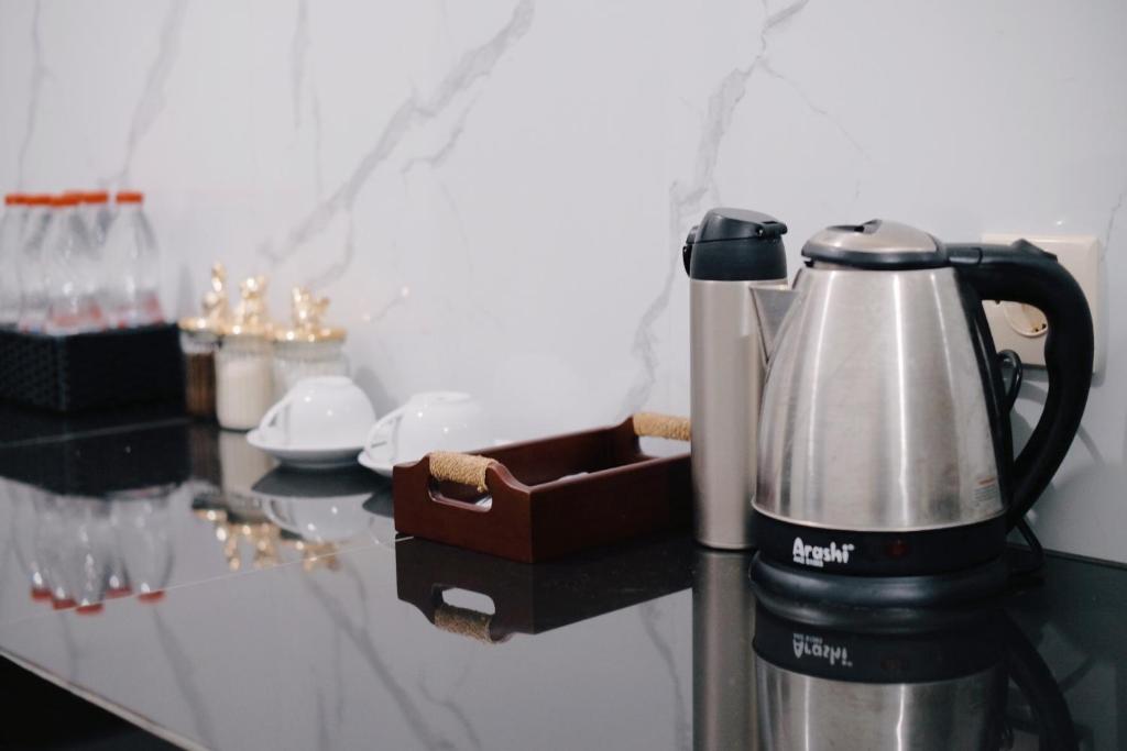 a coffee maker on a counter next to glasses at D Black Houze Banyuwangi in Banyuwangi